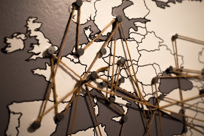This image shows a close up of a map including the UK and Europe. Capital cities are marked with a pin which are all joined up by a piece of string. 