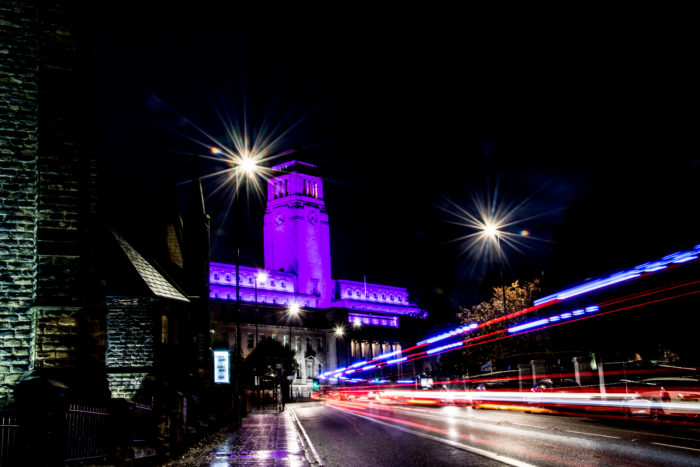 The Parkinson Building at night lit with purple light